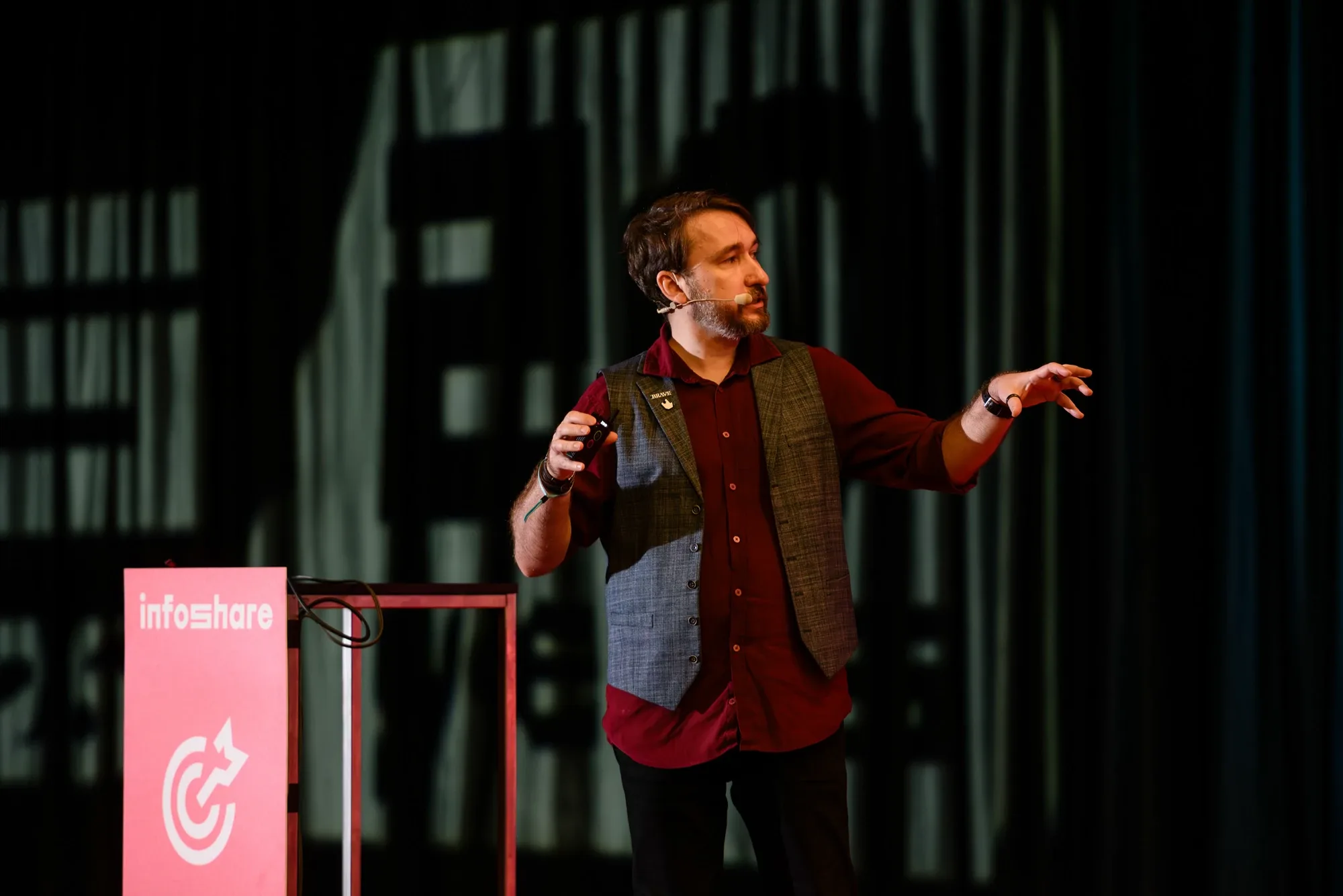 Krystian Wydro na scenie Marketing & Sales podczas Infoshare 2026, obok stojak z logo Infoshare