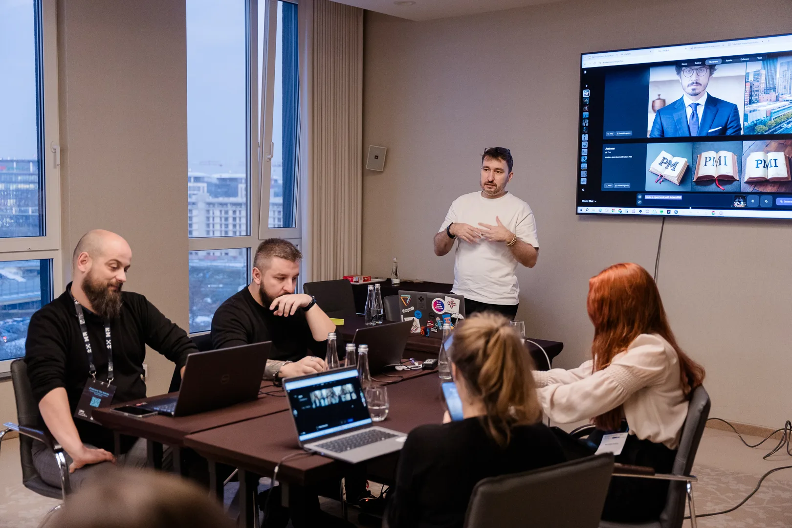 Krystian Wydro prowadzi warsztat na Kongresie PMI, mówiąc do grupy z laptopami przed ekranem z grafikami
