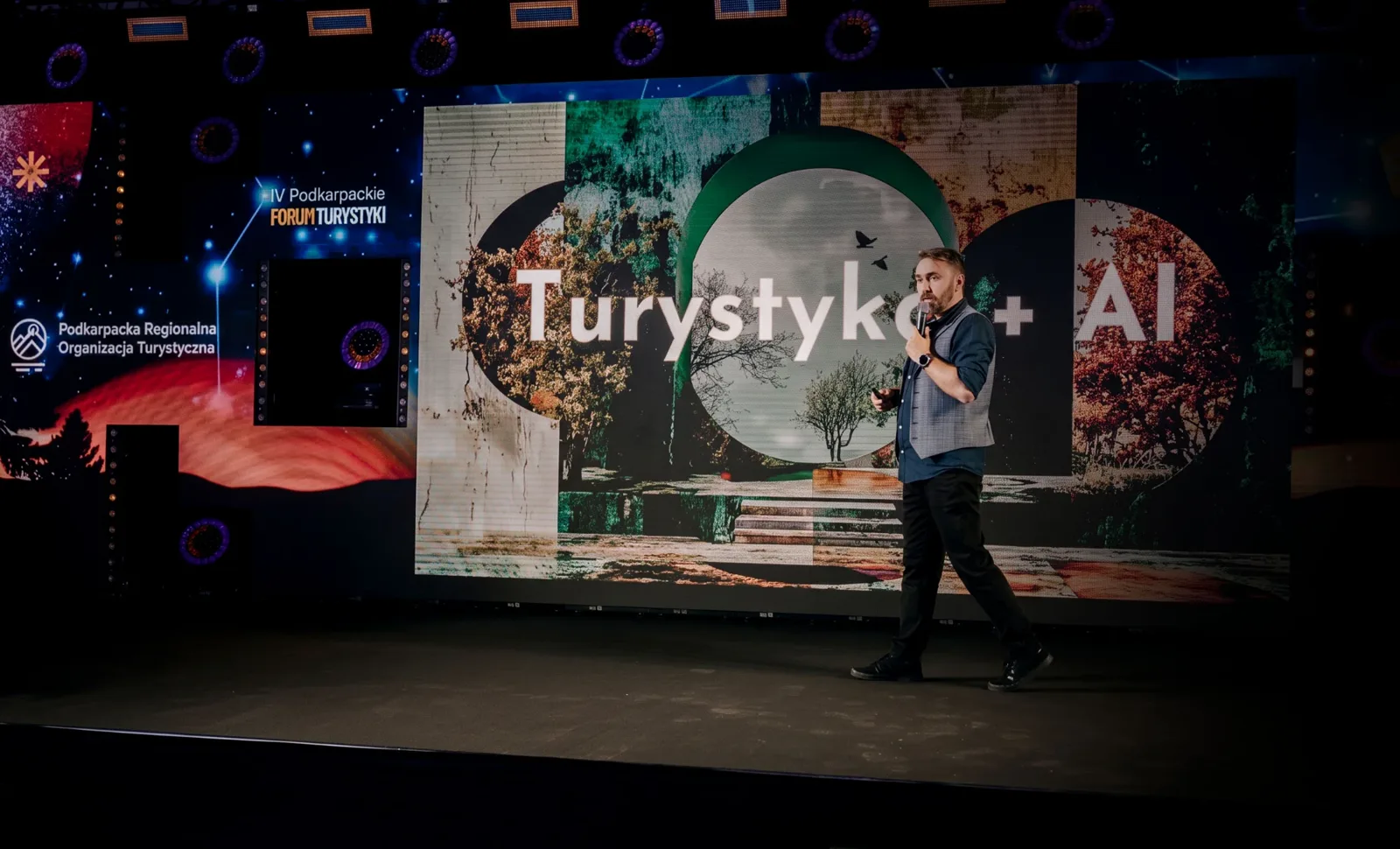 Krystian Wydro na scenie IV Podkarpackiego Forum Turystyki, na ekranie slajd „Turystyka + AI”